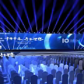 Large Event Venue With Blue Lighting Stage Backdrop Screen And Arranged Chairs