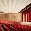Elegant Conference Room With Red Seats Stage Red Curtains Piano And Ceiling Lighting