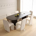 Modern Black Oval Table With White Upholstered Chairs Fruit Bowl and Book In Bright Room