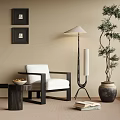White Upholstered Accent Chair With Black Frame Side Table Floor Lamp And Potted Tree