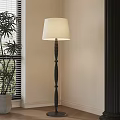 Cream Fabric Shade Floor Lamp With Black Textured Pole By Window And Green Plant