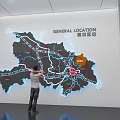 Person Viewing General Location Map With Roads And Area Markers On Wall