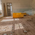 Abandoned Indoor Scene With Wooden Floor Yellow Sofa Windows Peeling Walls Wood Chips And Debris