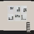 White Framed Black And White Photos Arranged On White Wall With Stacked Books