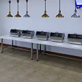 Unique Shaped Pendant Lights Above White Buffet Tables With Food Warmers In Restaurant