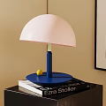 Modern Pink Lampshade Table Lamp with Blue Base on Black Cabinet and Books