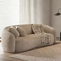Beige Fluffy Two-Seater Sofa with Cushions Patterned Blanket Window Blinds and Floor Lamp