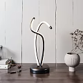Modern Curved Black White LED Table Lamp On Wooden Desk With Gray Vase Dried Flowers