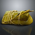 Traditional Chinese Zongzi Wrapped in Green Bamboo Leaves and Tied with String on Dark Glossy Surface