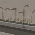 Different Styles Brushed Gold Faucets On White Countertop With Flowing Water