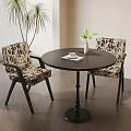 Stylish Black Round Dining Table Set With Patterned Chairs And Vase On Wooden Floor