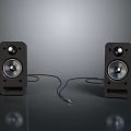 Black Speakers With Silver Drivers And Connecting Cable Placed On Grey Surface Against Dark Background 3d model