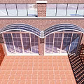 Arched Glass Entrance Gate Of Red Brick Building With Tiled Courtyard And Wooden Fence