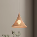 Conical Textured Pendant Light With Round Illuminated Bulb Against Light Colored Wall And Green Plants
