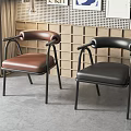Stylish Dining Chairs With Brown Black Leather Upholstery And Black Metal Frame Against Perforated Wall