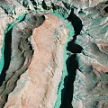 Aerial View Of Rocky Terrain With Winding Turquoise River And Colorful Canyon Landscape