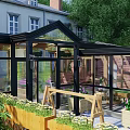 Modern Villa Balcony With Glass Roof Metal Frame And Lush Green Plants