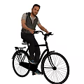 A man riding a classic black bicycle in casual style with rear rack