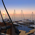 Scenic Sunset Over Calm Sea With Moored Sailboats At Wooden Dock And Orange Sky
