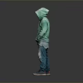 Man in Green Hoodie and Ripped Jeans Standing Against Gray Background with Sneakers