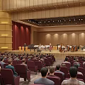 Concert Hall Interior Orchestra Performing On Stage With Audience In Red Seats