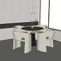 Modern Round Dining Table And White Chairs Set With Green Plant Vase In Indoor Room