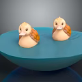 Two Adorable Small Duck Toys Sitting In Blue Decorative Bowl