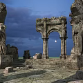Ancient Stone Ruins With Carved Archway Statues And Moonlit Night Sky