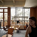 Warm Café Interior With Wooden Slat Walls Green Plants And Comfortable Seating