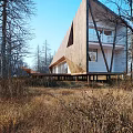 Modern Detached Villa With Slanting Wooden Roof And Stilted Base In Natural Woods