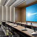 Modern Conference Room Interior Design With Long Tables Chairs Bottled Water Notebooks And Large Screen