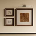 Framed Abstract Painting On Beige Wall With Smaller Artworks And Overhead Spotlight