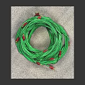 Neatly Coiled Green Cable With Red Ends Placed On Gray Mat