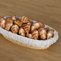Freshly Baked Croissants in Woven Basket with White Cloth on Wooden Table