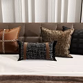 Brown and Black Decorative Pillows with Leather and Woven Textures on Bedroom Bed