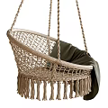 Natural Wicker Hanging Chair With Tassel Trim And Soft Green Blanket Accent