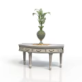 Light Colored Wooden Table With Drawers And Decorative Green Vase Holding Fern Plant