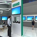 USHIO Exhibition Booth With Modern Design Multiple Blue Screens And People Interacting