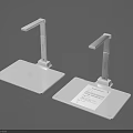 Two White Desktop Scanners With Flexible Arms And Paper On Base
