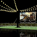 Outdoor Cinema With Yellow String Lights Large Movie Screen Green Carpet Foldable Chairs Potted Plants