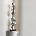 Silver Abstract Sculpture on Marble Base Against Light Colored Wall 3d model