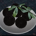 Black Fruits On White Plate With Green Leaves And Patterned Tablecloth