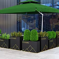Elegant Garden Decor with Black Planters Gold Geometric Accents and Green Topiaries Under Green Awning