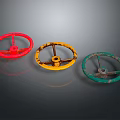 Three Worn Vintage Steering Wheels in Red Yellow Green on Gray Background