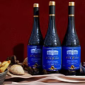 Three Dieu et Dames Wine Bottles With Wine Glasses Bread And Olives On Red Background