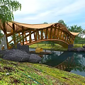 Scenic Wooden Bridge Structure Surrounded by Trees Pond and Green Grass