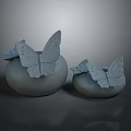 Two Light Gray Ceramic Vases With Delicate Butterfly Decorations On Smooth Matte Surface
