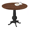 Round Wooden Dining Table With Black Carved Base White Bowl And Cups On Top