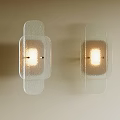 Textured Transparent Glass Wall Lamps Mounted On Light Colored Wall With Warm Lighting