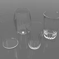 Four Transparent Glass Cups With Various Shapes And Designs On Smooth Surface